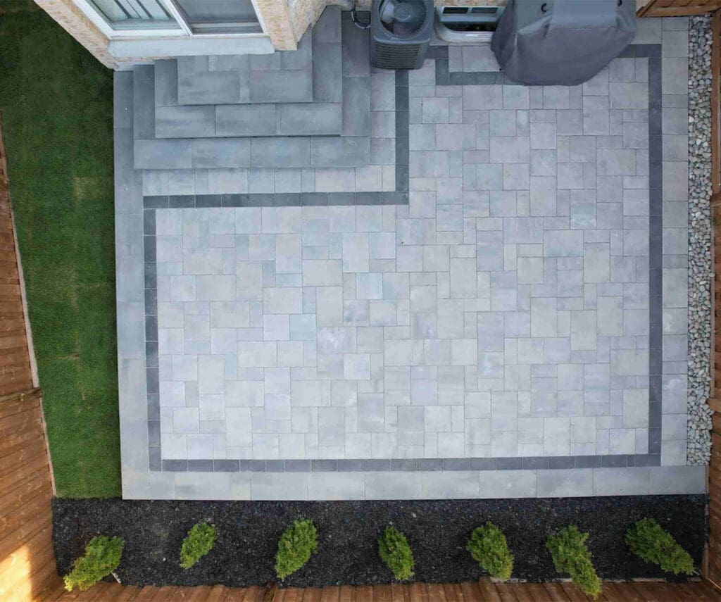 Drone-View-Grey-Interlocking-Patio-with-Cedar-Bushes