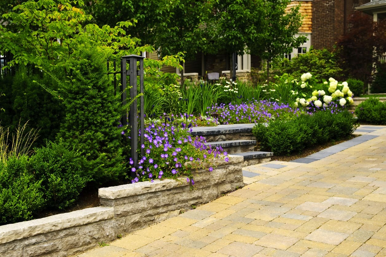 Elegant home with a spacious interlocking stone driveway and manicured front lawn, showcasing curb appeal and functional design.