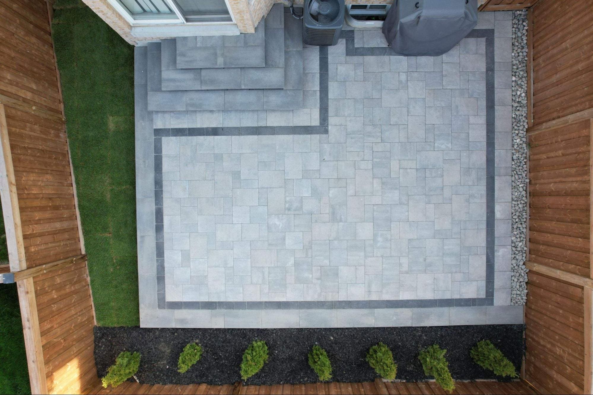 Aerial view of a rectangular interlocking patio with contrasting border design.