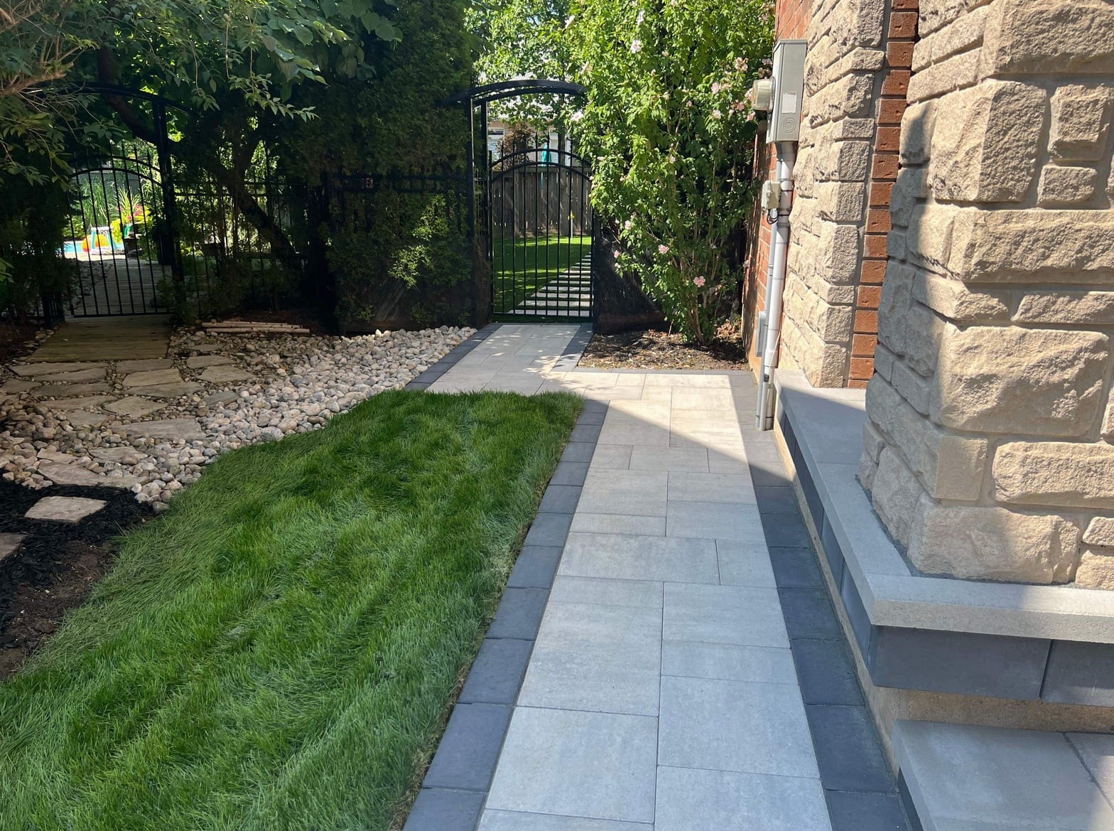 Interlocking paver walkway and front steps with wide landing leading to a home entrance.