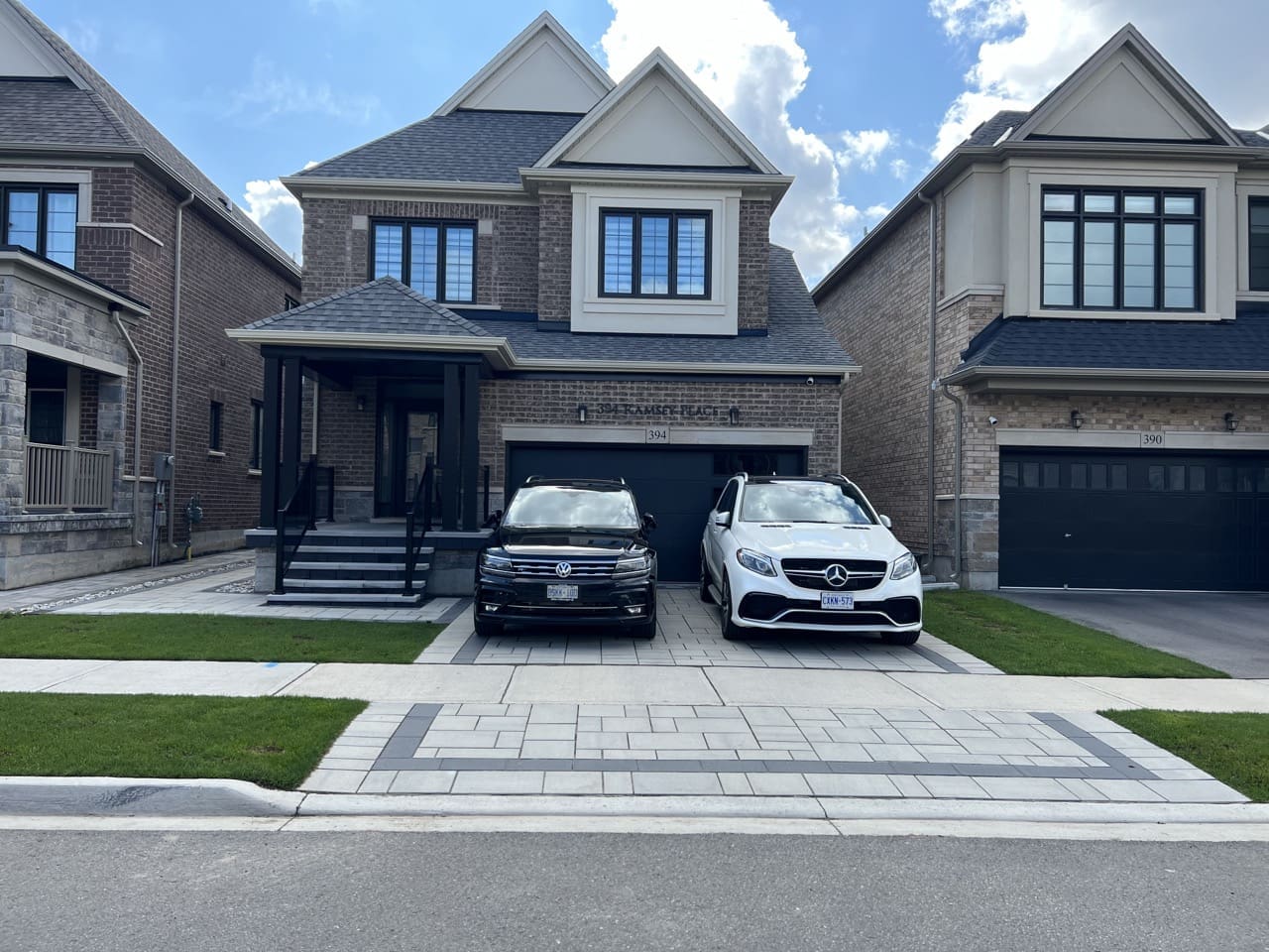 Stylish driveway interlock with contrasting charcoal border pattern and modern brick home facade with strong curb appeal.