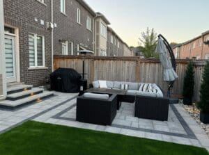 Small interlocking backyard in Milton with outdoor patio furniture and stone pavers.