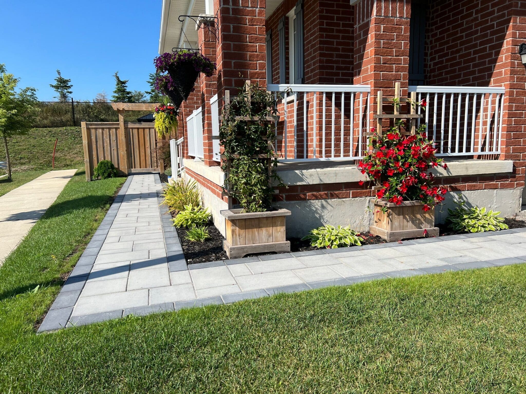 Interlocking Hamilton driveway with charcoal border pavers leading to a brick home's garage.